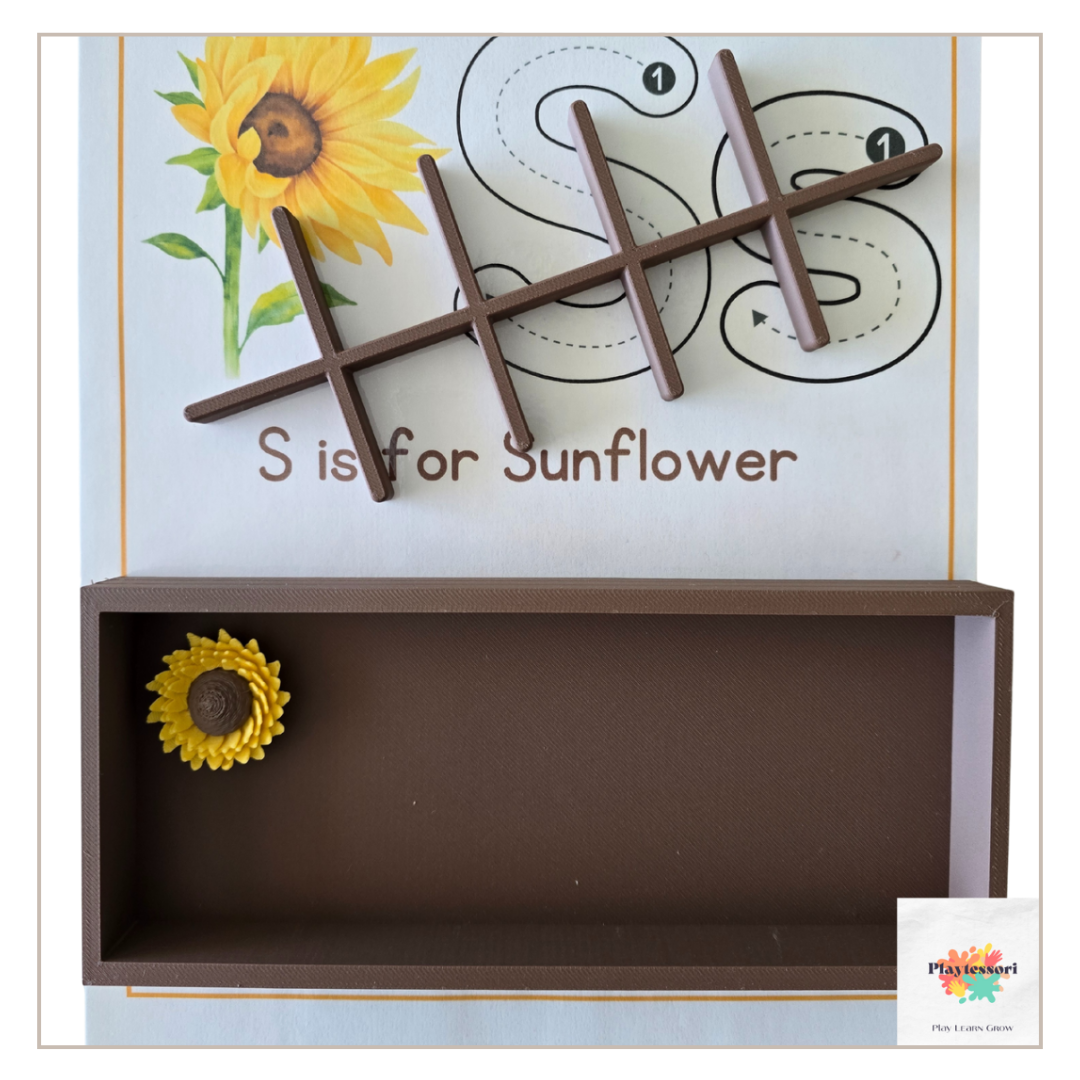 A close-up shot of the same brown, 3D-printed, rectangular tray with the removable grid insert removed. Three horizontal brown bars and three vertical brown bars are arranged in a large letter "S," placed on a piece of paper.