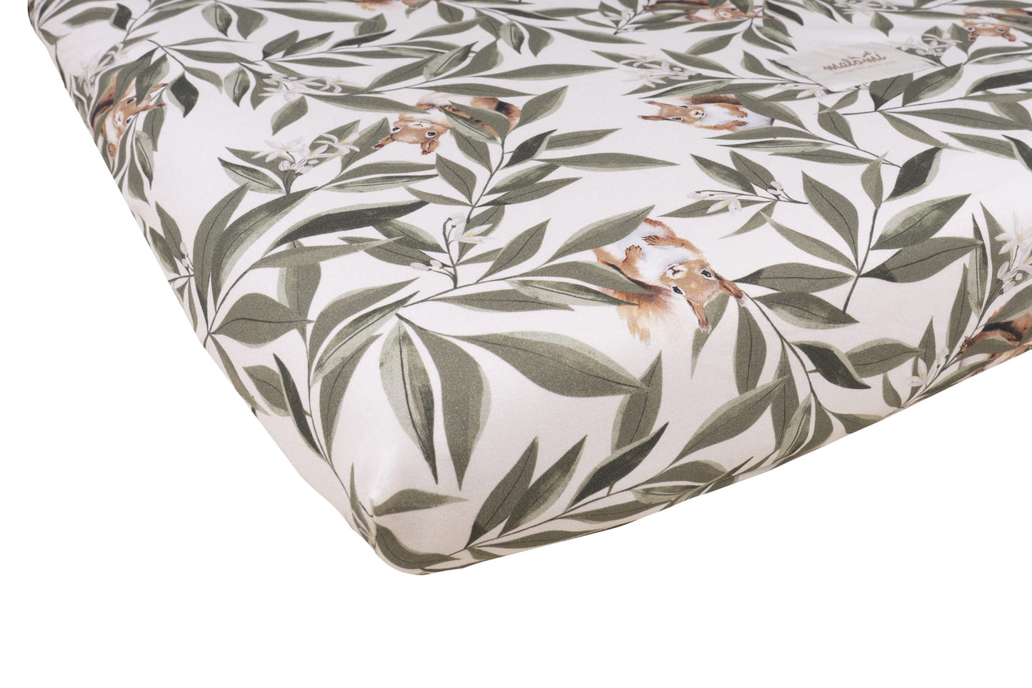 Close-up van een matras met woodland print, voorzien van groene bladeren en schattige eekhoorns op een crèmekleurige achtergrond.
