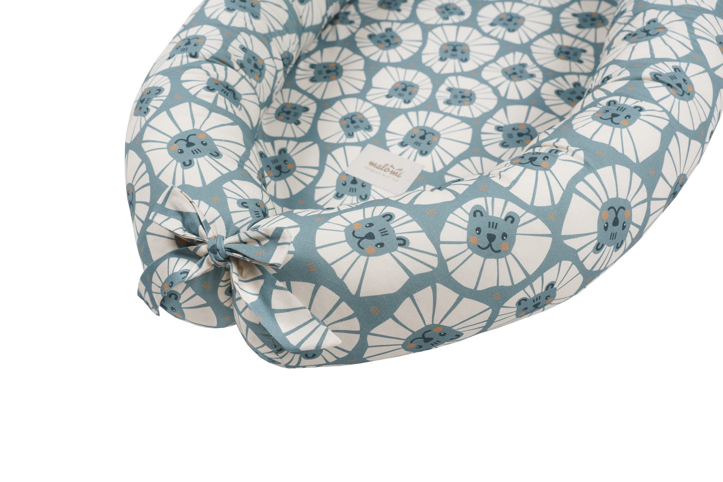 Detailweergave van het strikgedeelte aan het voeteneinde van het babynest Denim Lions, met label zichtbaar.