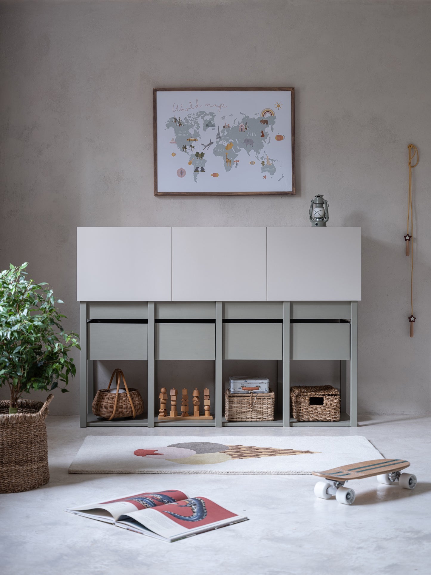 De Tweens commode in zandbeige en eucalyptusgroen staat prachtig in een lichte kinderkamer, compleet met een wereldkaart aan de muur. De open vakken onder de lades bieden ruimte voor manden en speelgoed, ideaal voor een geordende ruimte.