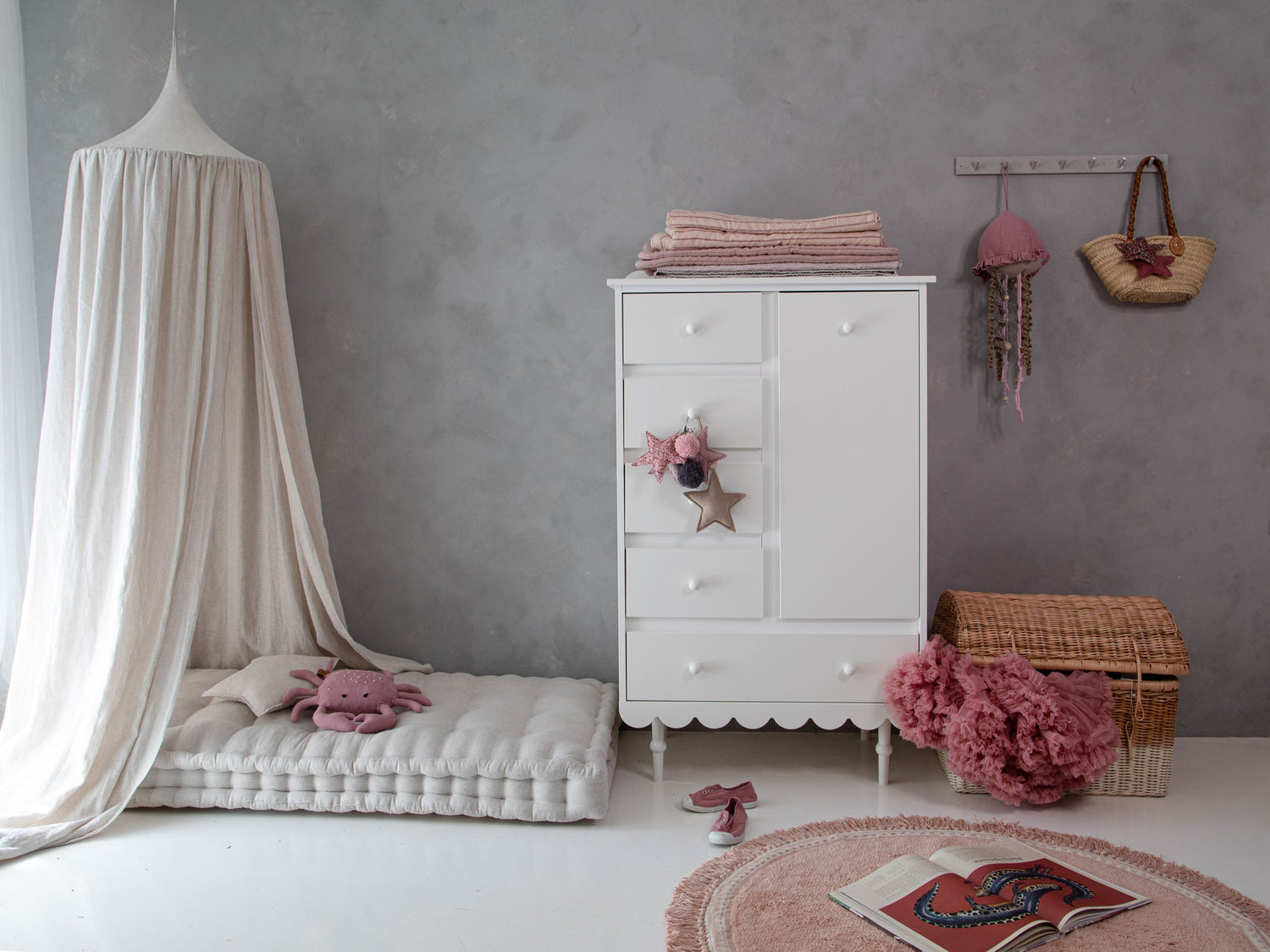 Witte Babushka commode in retrostijl met lades en kastdeur, in een sfeervolle kinderkamer met roze accenten en bedje