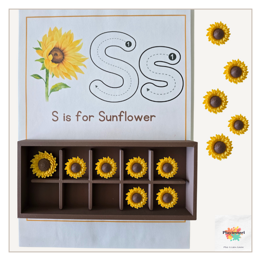 A close-up shot of a brown, 3D-printed, rectangular tray with a removable grid insert. The grid divides the tray into ten compartments, and a small, yellow sunflower figure is placed in the leftmost compartment.