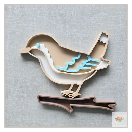 A beige, 3D-printed bird bio sensory tray with removable pieces, including a white belly, a light blue wing, and a separate brown branch piece for the bird to stand on.