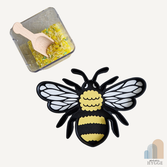 Sensorische tray in de vorm van een hommel, gevuld met gele speelrijst – perfect voor Montessori- en natuurspel.