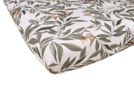 Close-up van een matras met woodland print, voorzien van groene bladeren en schattige eekhoorns op een crèmekleurige achtergrond.