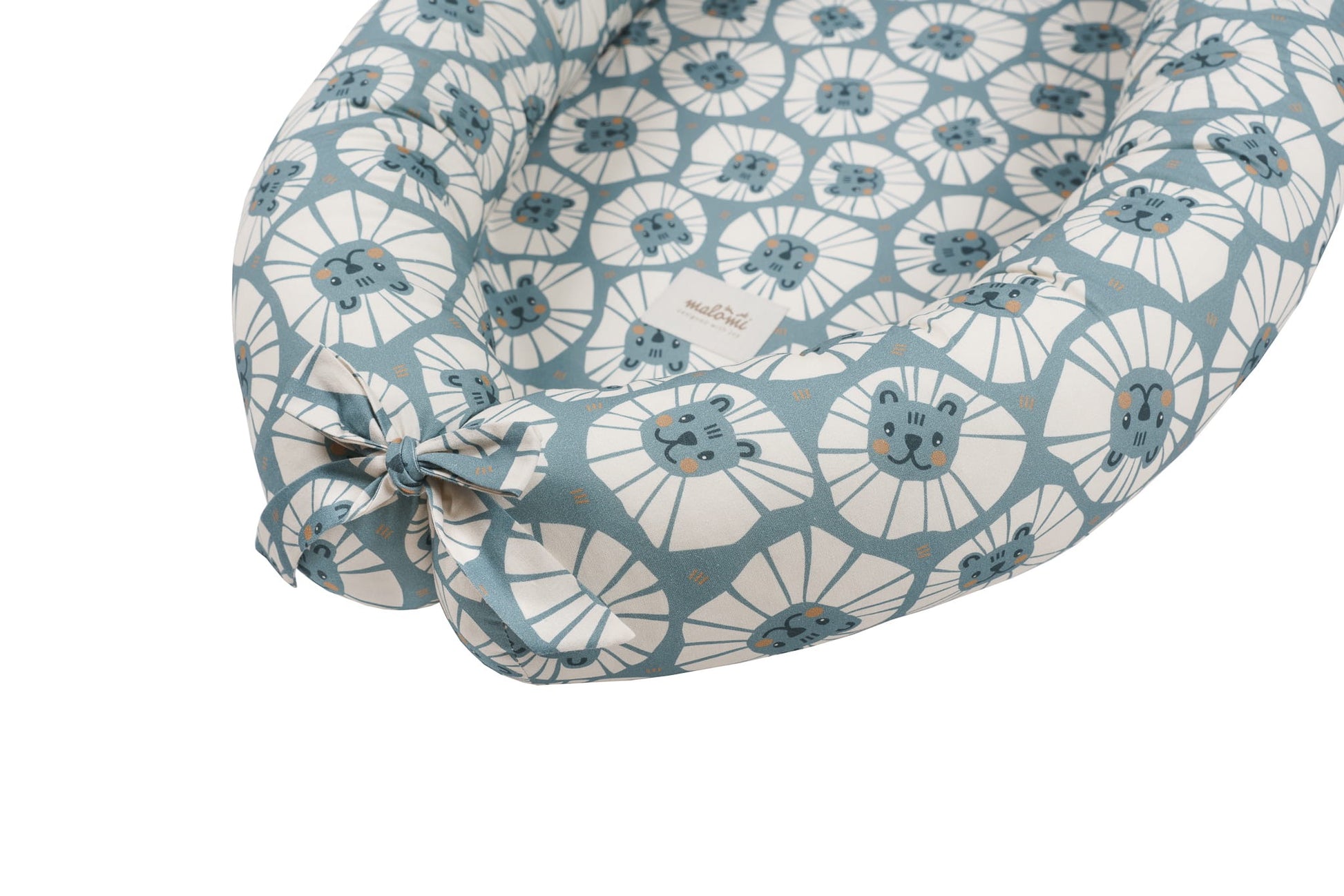Detailweergave van het strikgedeelte aan het voeteneinde van het babynest Denim Lions, met label zichtbaar.
