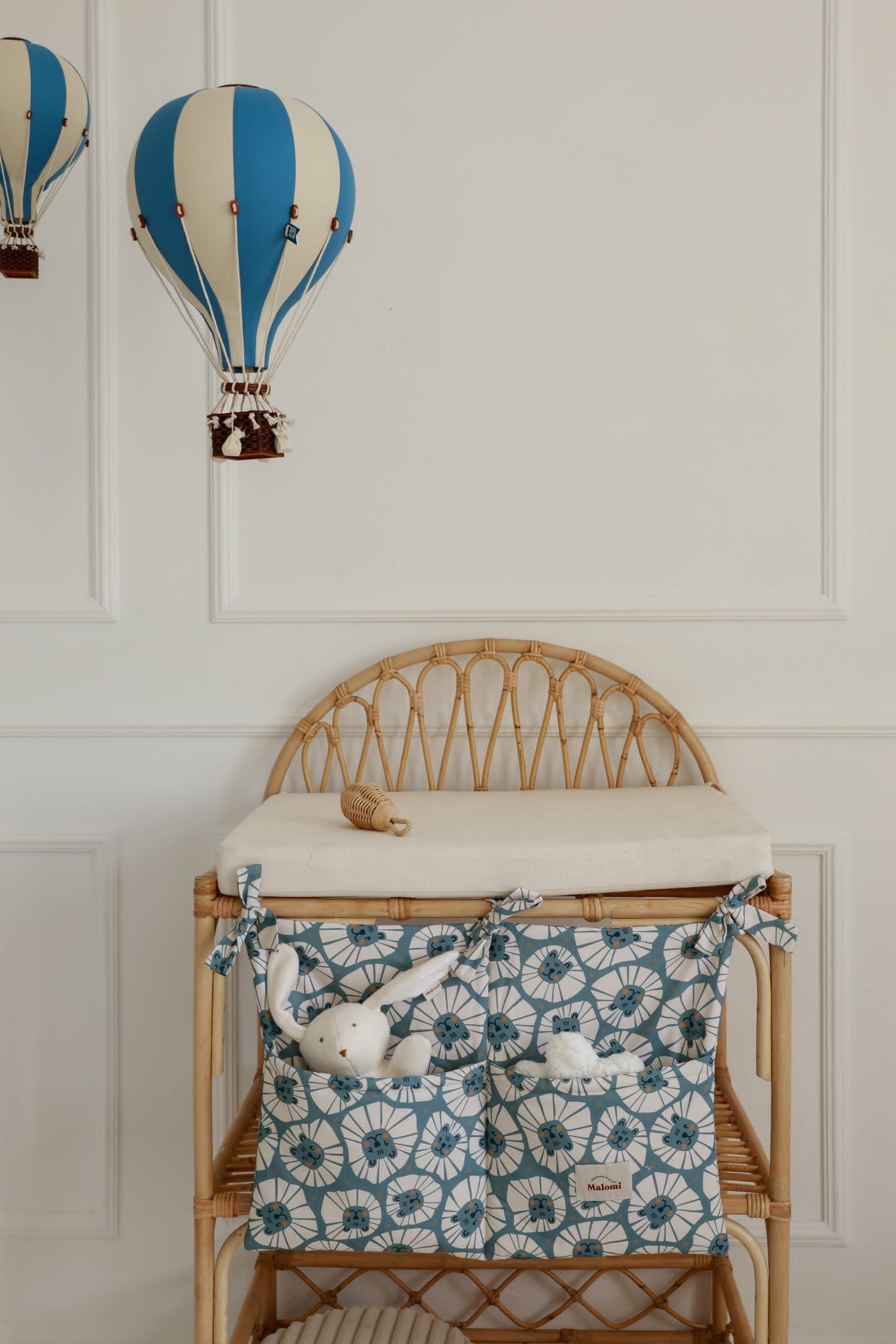 Organizer met strikjes, denim leeuwenprint, aan commode op achtergrond met luchtballonnen