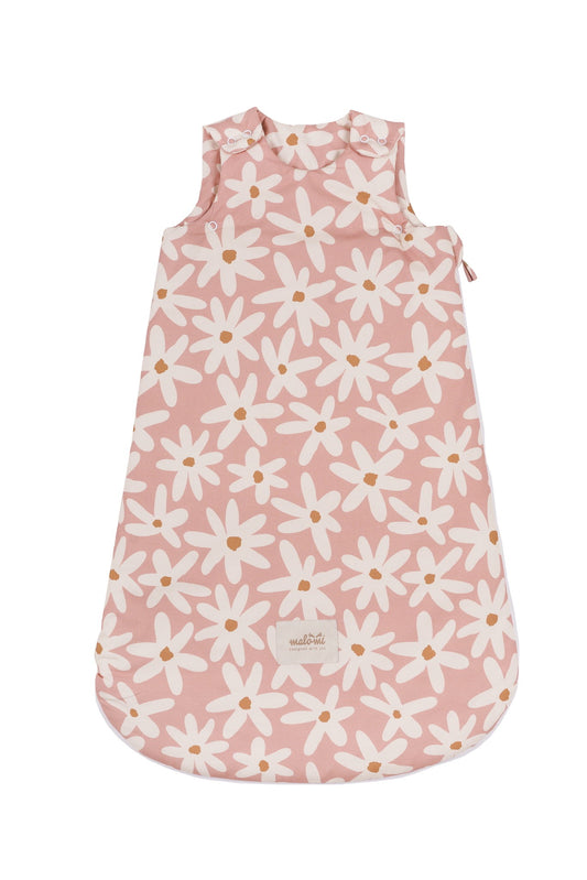 Blushroze babyslaapzak met witte madeliefjesprint, plat gelegd op witte achtergrond, met Malomi-label aan de onderkant.