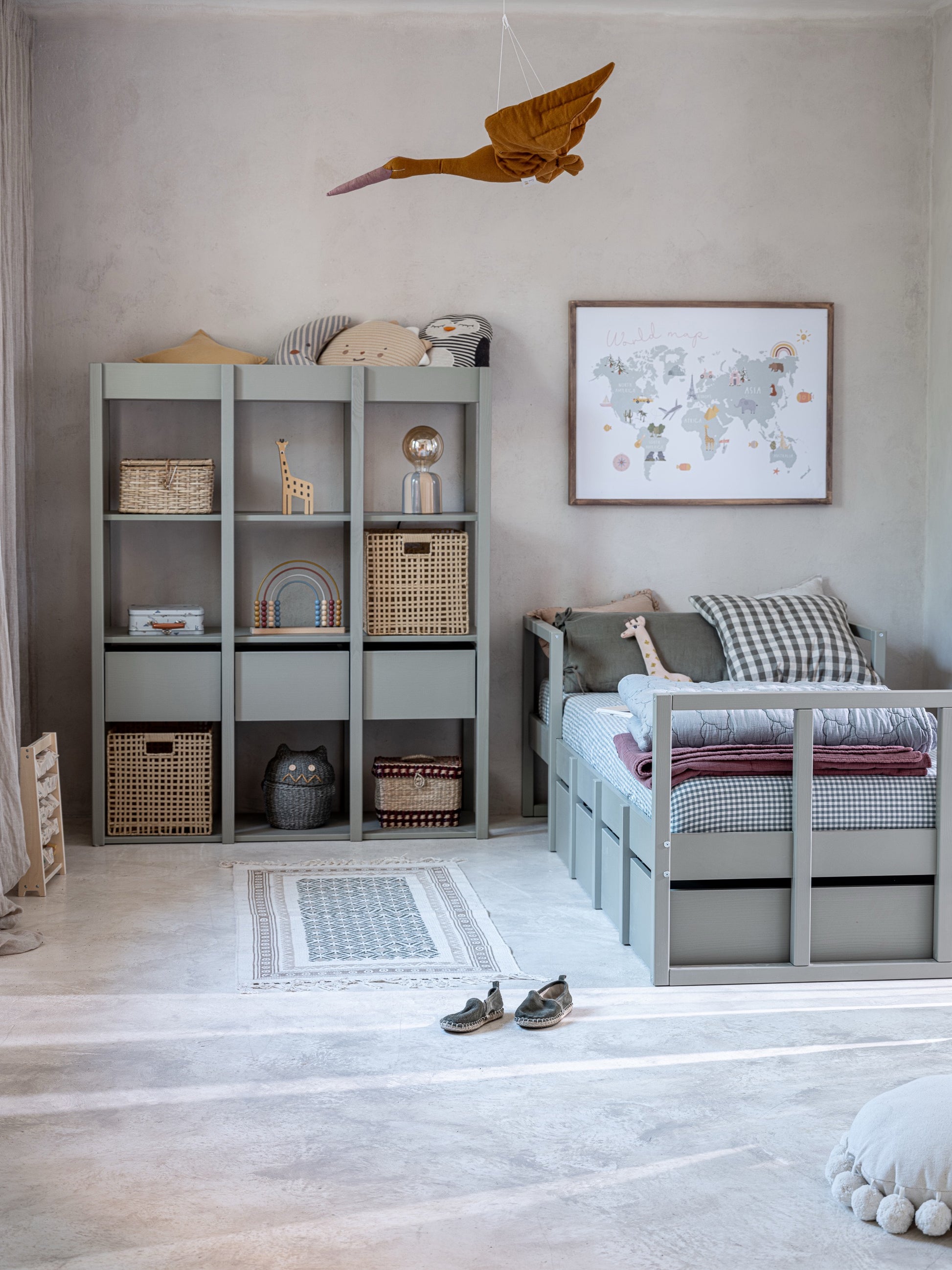 De Tweens boekenkast in Eucalyptusgroen staat in een lichte kinderkamer, volledig ingericht met boeken, manden en decoraties. Naast de kast staat een bijpassend bed, wat de harmonieuze uitstraling van de collectie toont.